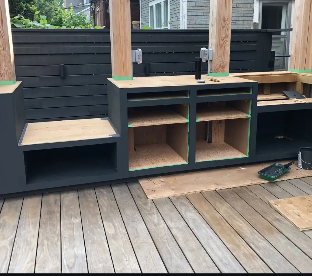 Cabinet carcasses painted dark with timber tops fitted, ready for appliances