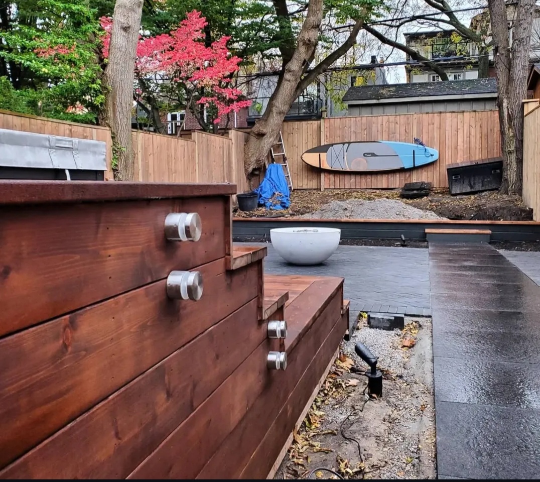 The same garden mid-build in daylight, before planting and lighting